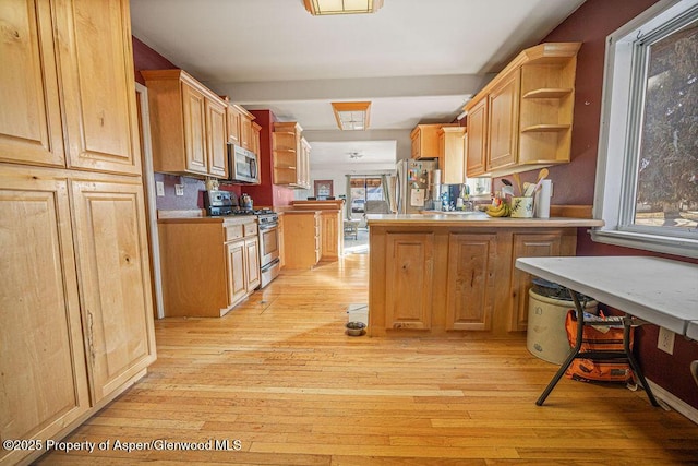 kitchen featuring stainless steel appliances, light wood-style floors, plenty of natural light, and open shelves