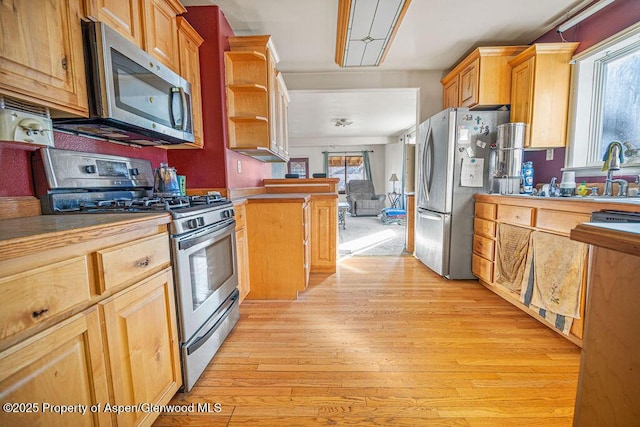 kitchen with stainless steel appliances, light wood-type flooring, open shelves, and a healthy amount of sunlight