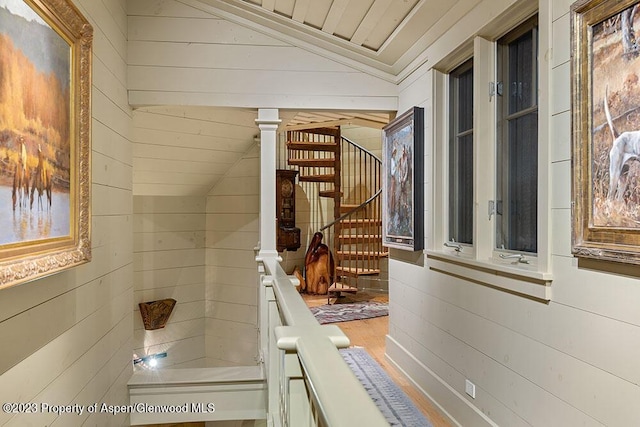 interior space with vaulted ceiling and wood walls