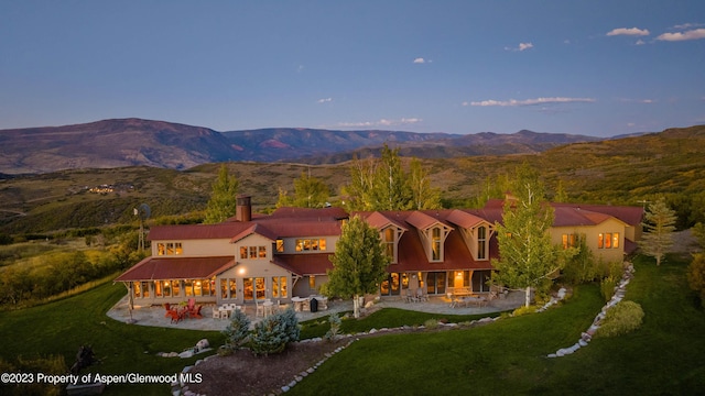 aerial view at dusk featuring a mountain view