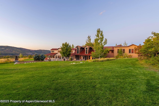 yard at dusk featuring a mountain view