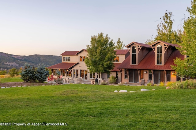 view of front of house with a lawn and a patio area