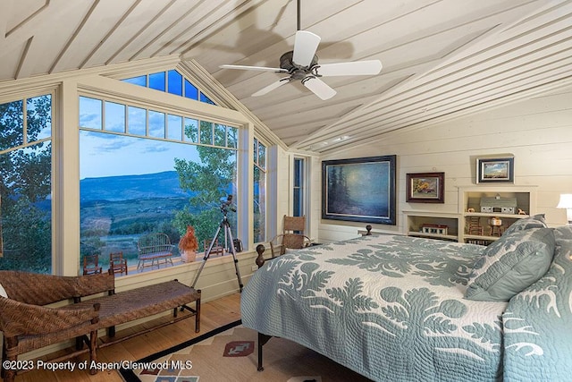 bedroom featuring a mountain view, hardwood / wood-style floors, ceiling fan, and lofted ceiling