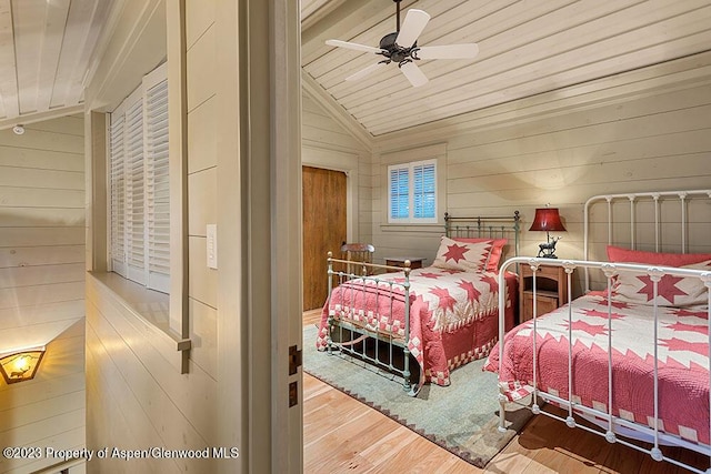 bedroom featuring wood walls, wood-type flooring, and wooden ceiling