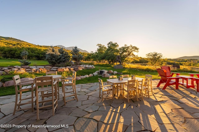 patio terrace at dusk featuring a mountain view