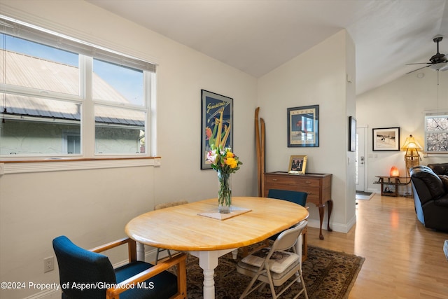 dining area with ceiling fan, light hardwood / wood-style flooring, and vaulted ceiling