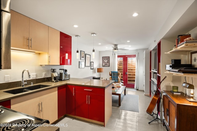 kitchen featuring sink, ceiling fan, kitchen peninsula, and pendant lighting