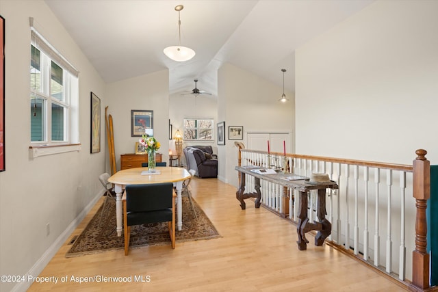 dining room featuring ceiling fan, light wood-type flooring, and lofted ceiling