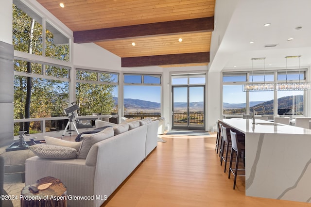 living room featuring wood ceiling, beam ceiling, wood finished floors, and a mountain view