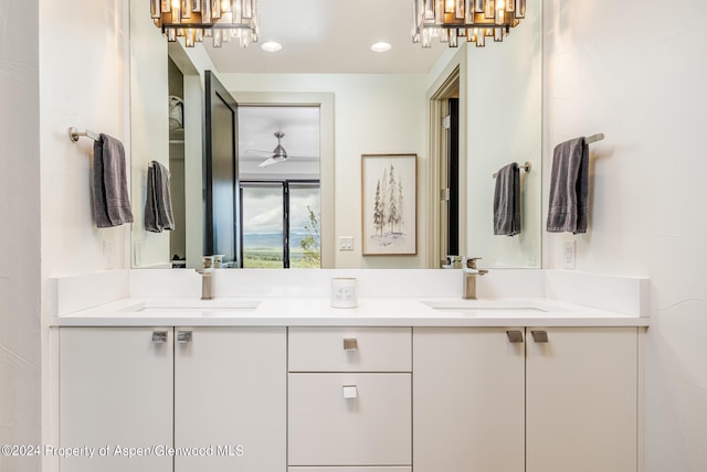 bathroom featuring a chandelier, recessed lighting, a sink, and double vanity