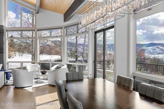 interior space featuring wood ceiling, beamed ceiling, wood finished floors, a mountain view, and a notable chandelier