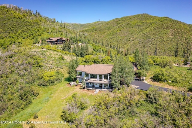 drone / aerial view with a mountain view and a view of trees