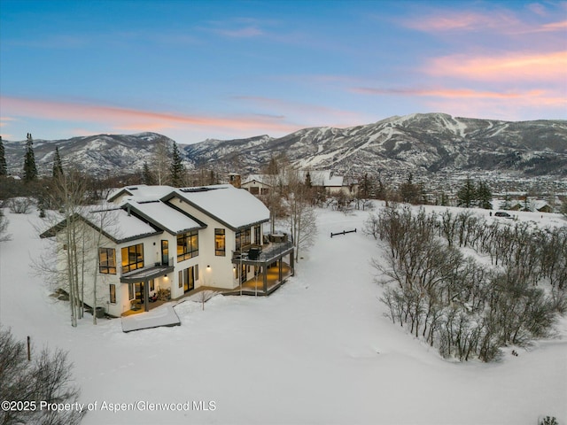 snowy aerial view featuring a mountain view