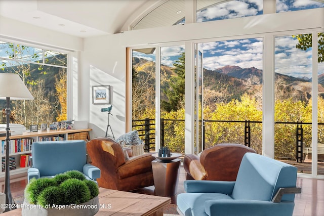 sunroom / solarium with a mountain view and lofted ceiling