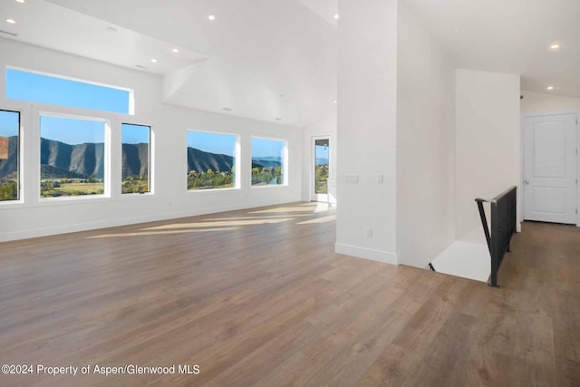 unfurnished living room with vaulted ceiling and hardwood / wood-style flooring