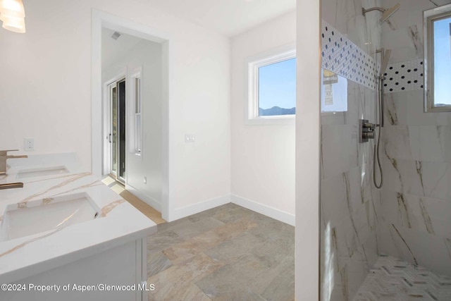 bathroom featuring tiled shower and vanity