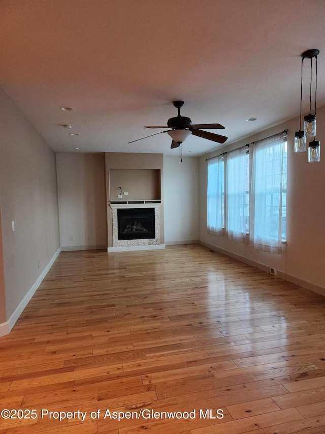 unfurnished living room with light hardwood / wood-style floors and ceiling fan