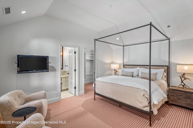 carpeted bedroom featuring ensuite bathroom and lofted ceiling