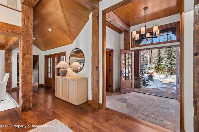 entryway with dark wood-type flooring, a high ceiling, french doors, a notable chandelier, and wood ceiling