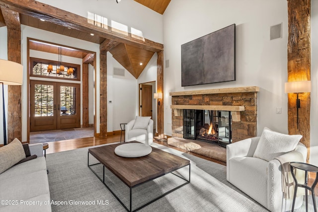 living room with wood ceiling, a fireplace, high vaulted ceiling, and french doors