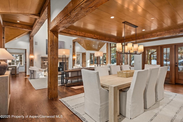 dining space featuring lofted ceiling with beams, hardwood / wood-style flooring, plenty of natural light, and wood ceiling