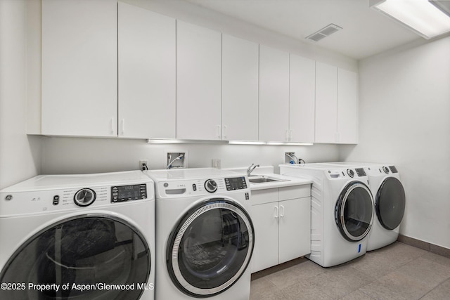 laundry area with washing machine and clothes dryer, sink, and cabinets