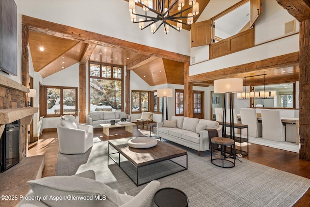 living room with an inviting chandelier, a stone fireplace, hardwood / wood-style flooring, beam ceiling, and wood ceiling