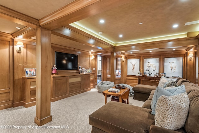 carpeted living room featuring beam ceiling, wood walls, and ornamental molding