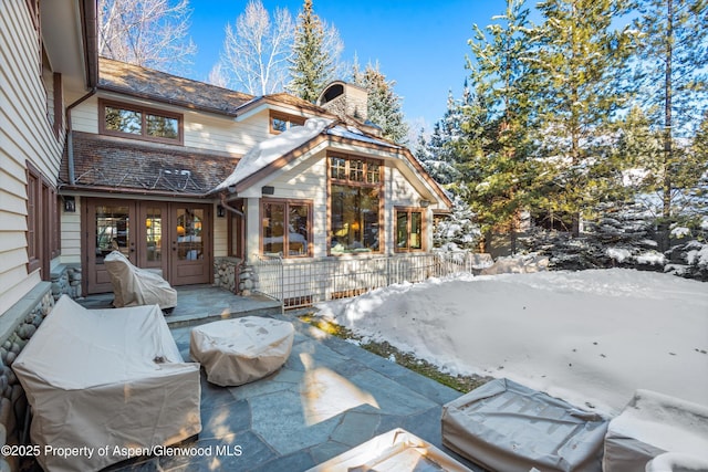 view of snow covered exterior with french doors