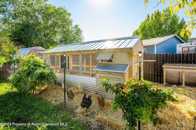 rear view of house featuring an outdoor structure