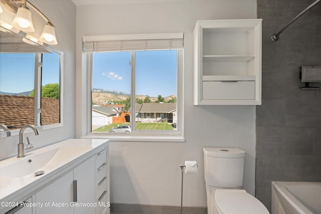 full bathroom with vanity, tiled shower / bath combo, and toilet