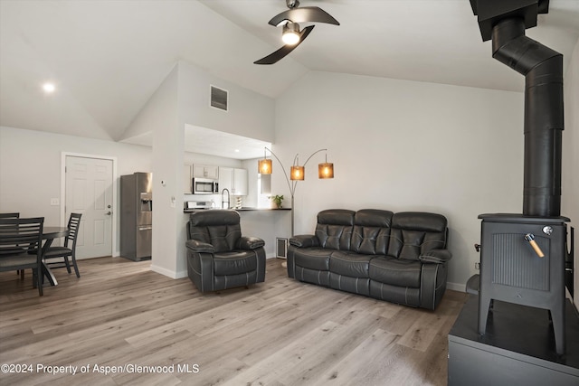 living room featuring ceiling fan, sink, light hardwood / wood-style floors, and lofted ceiling