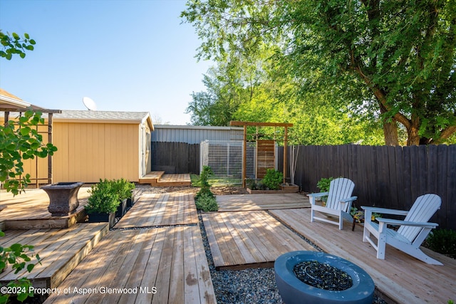 deck featuring a storage unit and an outdoor fire pit