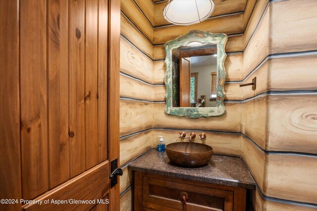 bathroom with vanity and log walls