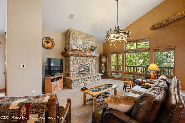 carpeted living room featuring a fireplace, high vaulted ceiling, an inviting chandelier, and plenty of natural light