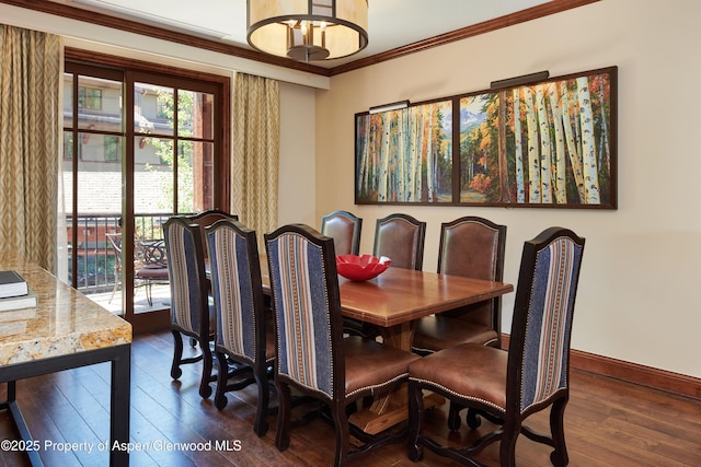 dining area featuring crown molding, baseboards, and dark wood finished floors