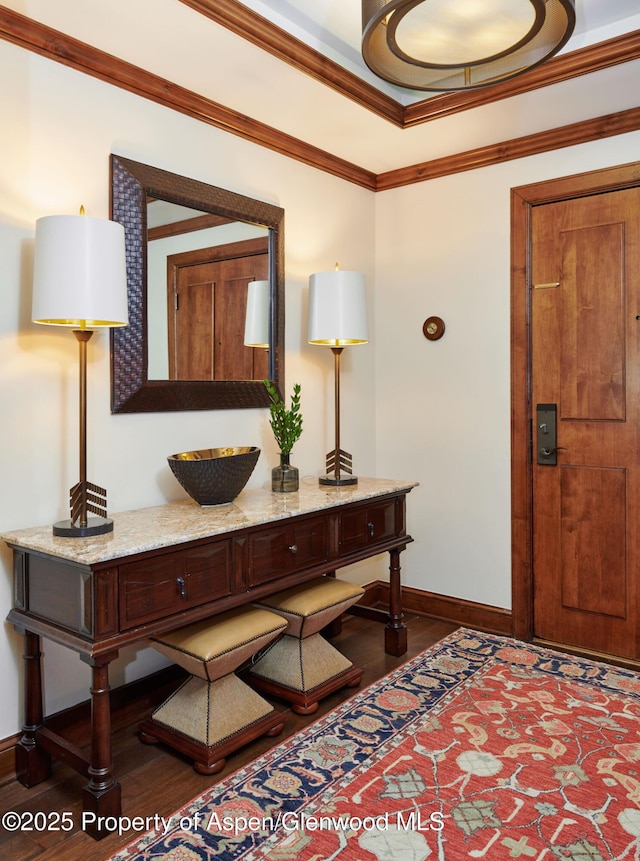 foyer entrance with ornamental molding, baseboards, and dark wood-style flooring