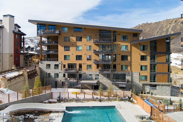 view of swimming pool with a mountain view and pool water feature