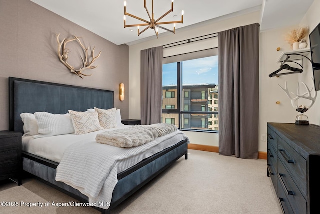 bedroom featuring light carpet and an inviting chandelier