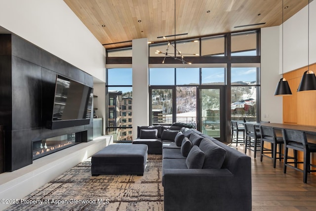 living room with dark hardwood / wood-style floors, wooden ceiling, floor to ceiling windows, and a high ceiling