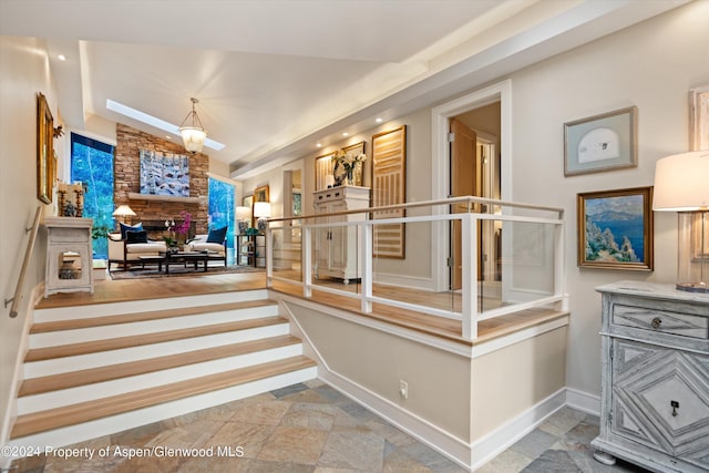 stairway featuring a fireplace and lofted ceiling