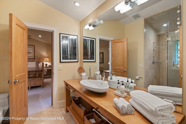 bathroom featuring vanity, vaulted ceiling, tile patterned flooring, toilet, and walk in shower