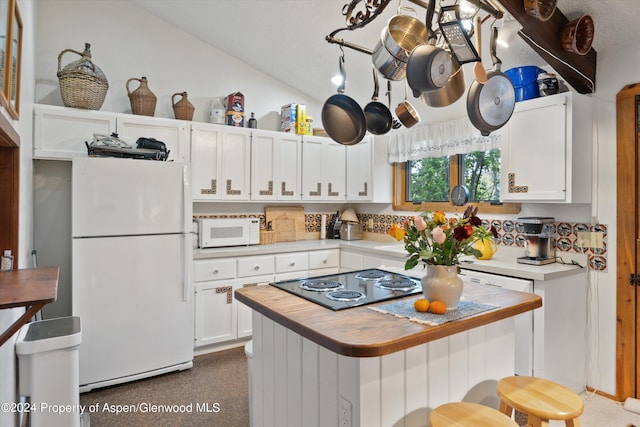 kitchen with white cabinetry, lofted ceiling, white appliances, a breakfast bar, and a kitchen island