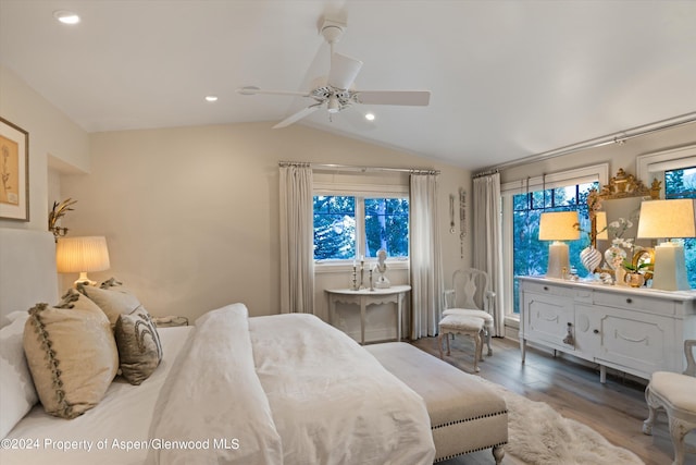 bedroom with ceiling fan, hardwood / wood-style floors, and vaulted ceiling