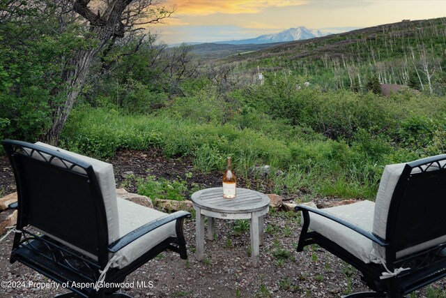 yard at dusk featuring a mountain view and a patio area