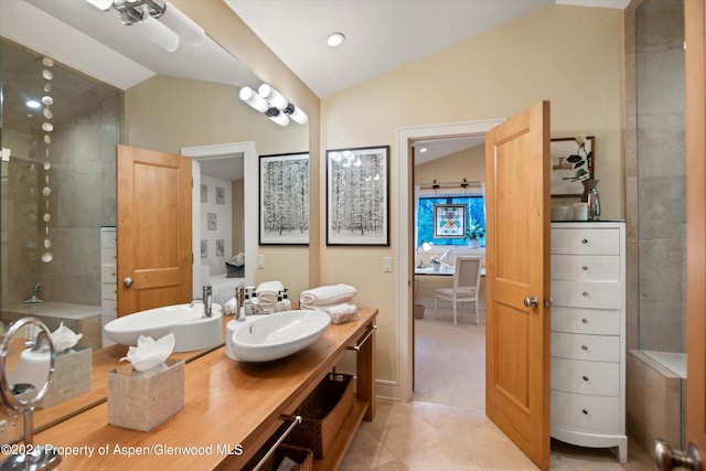 bathroom featuring tile patterned floors, vanity, and vaulted ceiling