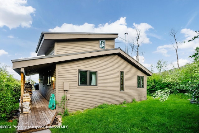 rear view of property featuring a yard and a wooden deck