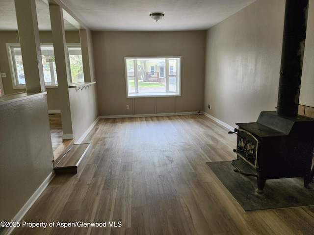 737 Rose St, Craig, CO 81625 - unfurnished living room featuring a wood stove, wood finished floors, and baseboards