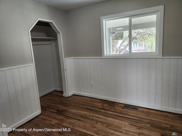 737 Rose St, Craig, CO 81625 - unfurnished room featuring wainscoting, dark wood-style flooring, and wood walls