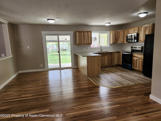 737 Rose St, Craig, CO 81625 - kitchen with electric range, stainless steel microwave, freestanding refrigerator, a peninsula, and decorative backsplash
